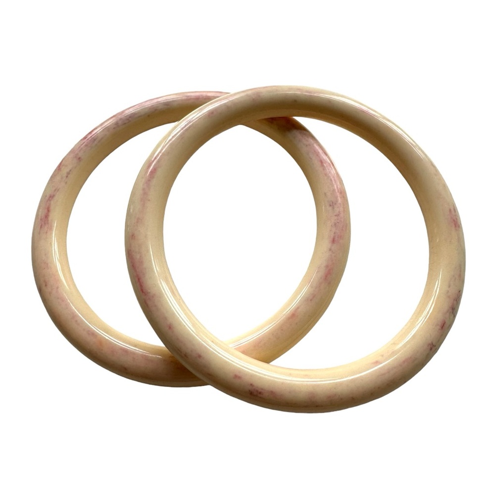 Pair of cream resin round bangle bracelets.